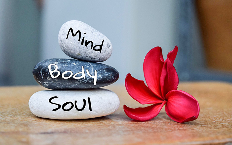 Holistic health zen stones. Text with body mind soul