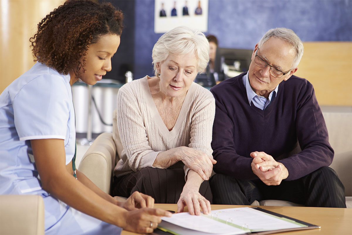 Senior Couple Meeting With Nurse In Hospital.