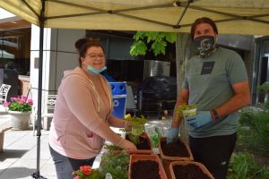 Smiling man and woman working with plants