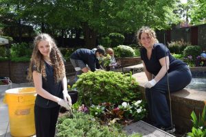 women working in plant garden near fountain