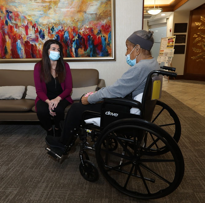 Woman and man in wheelchair in Margaret Tietz lobby