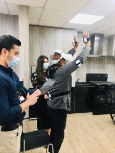 Senior in VR headset standing with arms raised