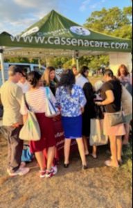 group of people gathered close to the Cassena Care tent at QJCC